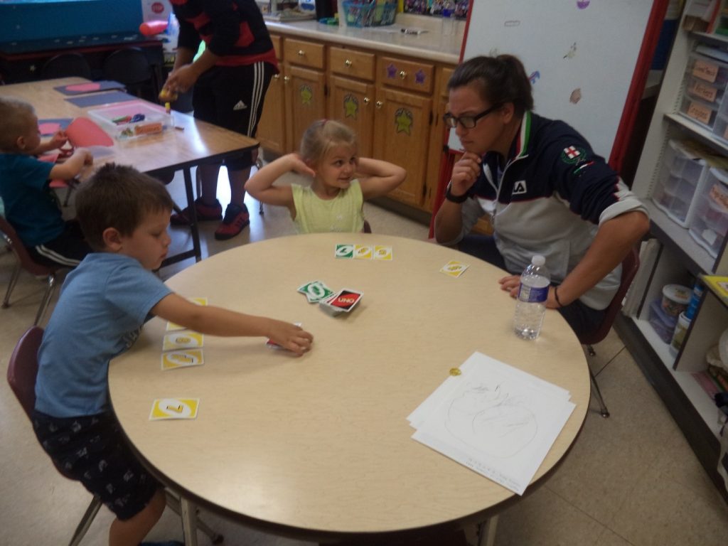 pre-schooler playing card game with adult